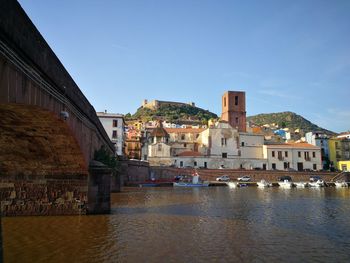 River amidst buildings in town against sky