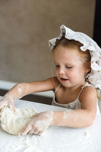 Little girl cooking pizza in the kitchen