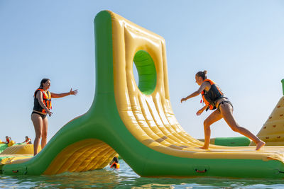 Inflatable bounce castle floats in park for children having fun in water with attractions in the sea