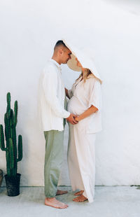 The wife is a loving couple. a husband hugs his pregnant wife's belly. woman in a hat.