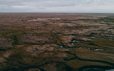 Aerial view of land and sea against sky