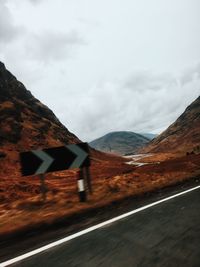 Mountain road against cloudy sky