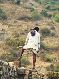 Rear view of woman standing on rock