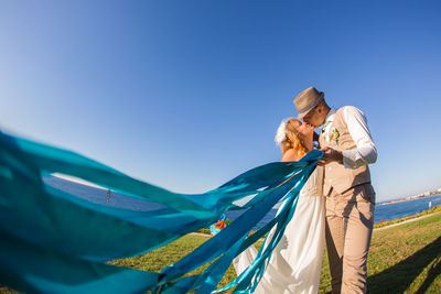 Low angle view of women against blue sky