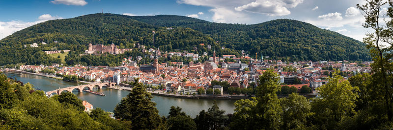 Panoramic view of townscape and mountains against sky