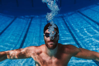 Professional young male swimmer swimming underwater