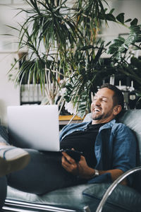 Man looking at camera while sitting in laptop