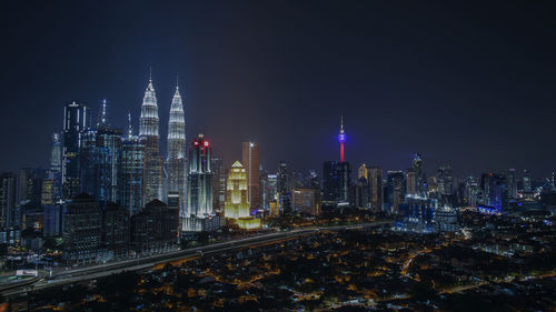 Illuminated buildings in city against sky at night