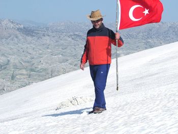 Full length of man standing on mountain road during winter