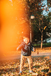 Full length portrait of boy standing on land during autumn