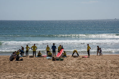 People at beach against sky