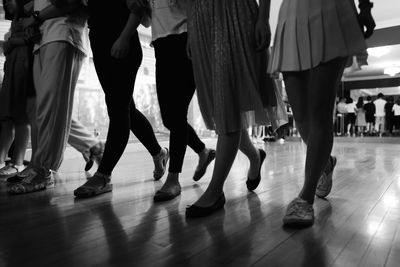 Low section of people dancing on hardwood floor