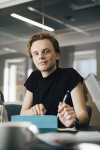 Businesswoman discussing with transgender colleague over laptop in board room during meeting