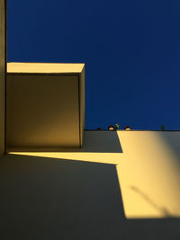 Low angle view of yellow building against blue sky