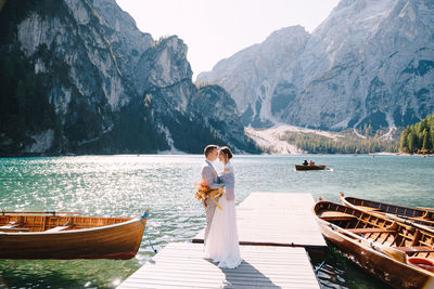 Woman standing on lake against mountains