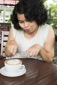 Young woman with coffee cup on table
