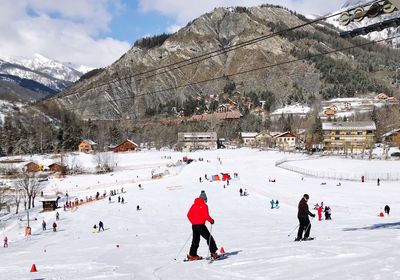 People enjoying on snow covered mountains