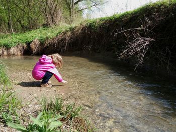 Woman sitting on riverbank