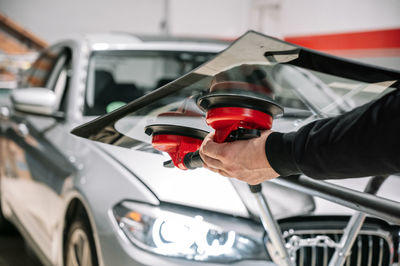 Midsection of man holding car