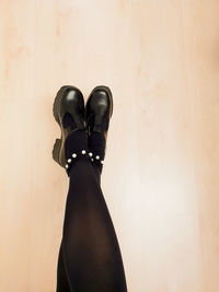 Low section of person standing on hardwood floor