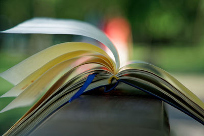 Close-up of open diary on railing at park