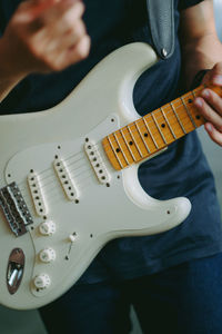 Midsection of man playing guitar