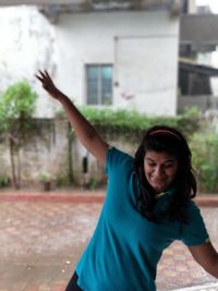 Young woman balancing while standing on footpath