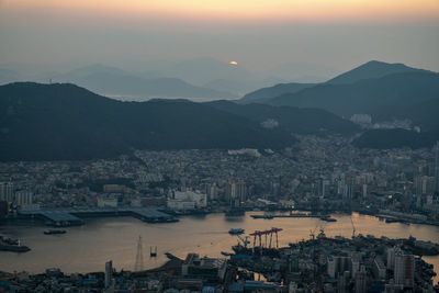 High angle view of buildings and mountains against sky during sunset