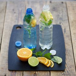 High angle view of drinks in bottle with citrus fruits on table