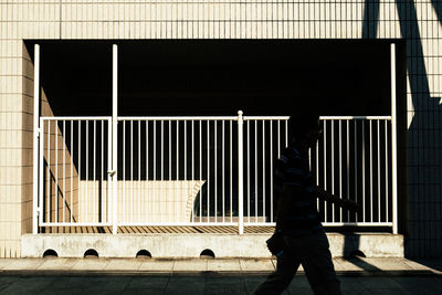 Side view of man standing against built structure