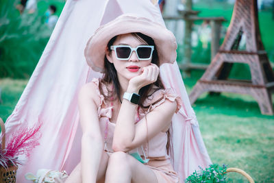 Young woman wearing sunglasses sitting outdoors