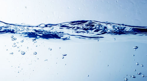 Close-up of water splashing against blue background