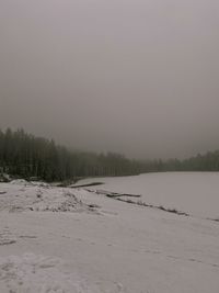 Scenic view of snow covered field against sky