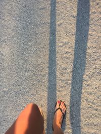 Low section of woman standing on road