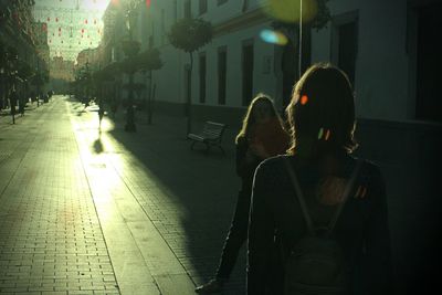 Rear view of people walking on street at night