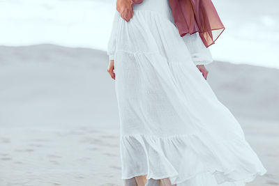 Midsection of woman standing on beach