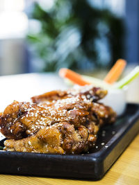 Close-up of chicken wings with sesame seeds served in plate on table