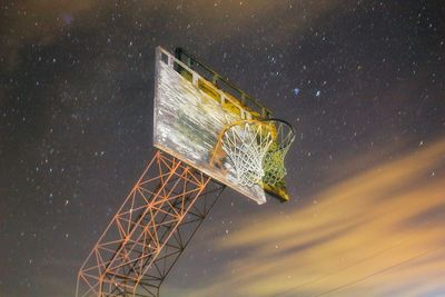 Digital composite image of basketball hoop against star field at night