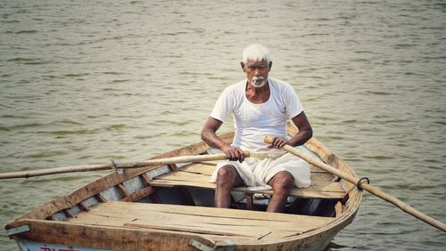 Full length of man sitting on boat in sea