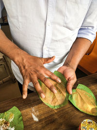 Midsection of man preparing food on table