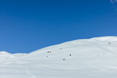 Scenic view of snowcapped mountains against clear blue sky