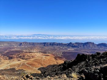 Scenic view of mountains against blue sky