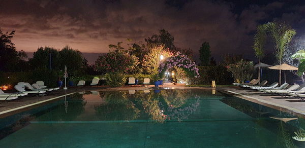 Panoramic view of swimming pool by lake against sky