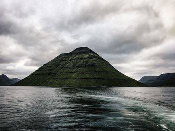 Scenic view of mountain by sea against sky