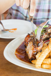 Close-up of hand in plate on table