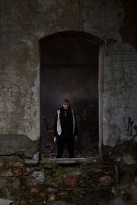 Portrait of man standing against wall