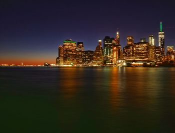 Illuminated city at waterfront at night
