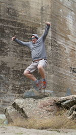 Full length of man jumping against wall