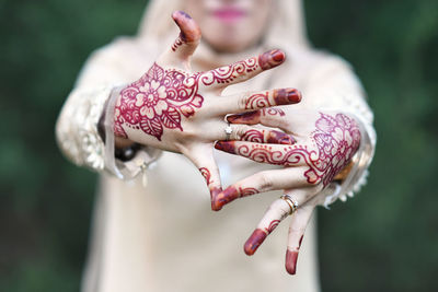 Midsection of bride showing engagement ring while standing outdoors