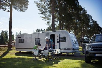 Family having meal in front of camper trailer